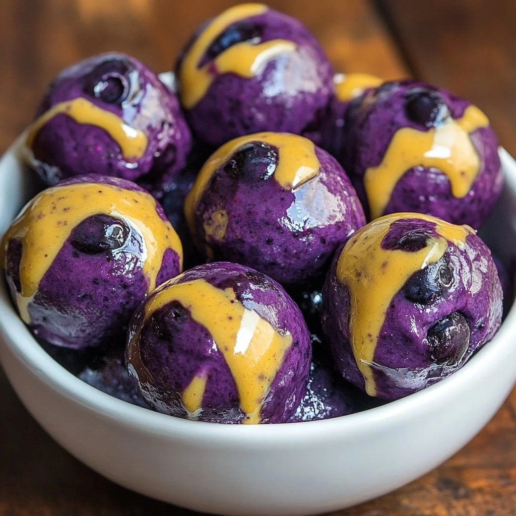 Blueberry cheesecake protein bites on a plate, a healthy snack option.