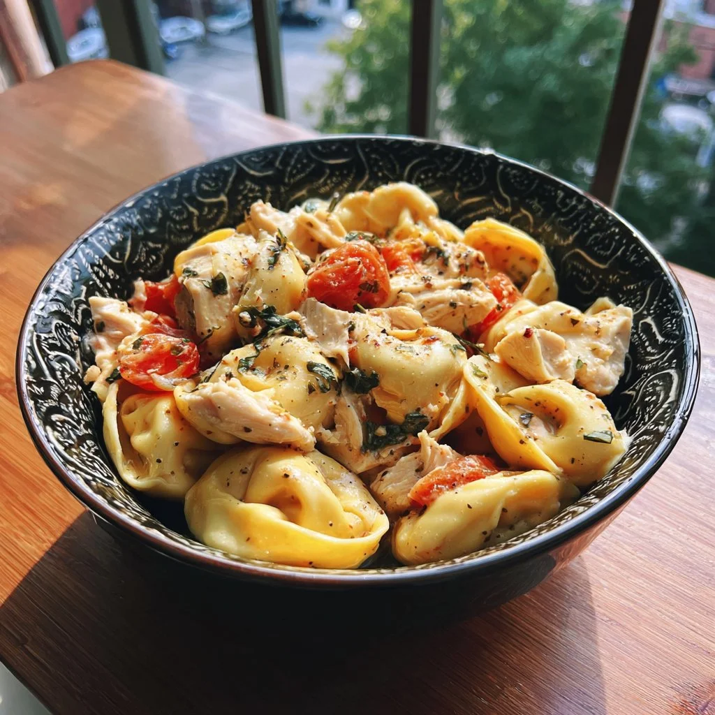 Delicious CrockPot chicken tortellini served in a bowl with fresh herbs