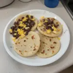 Homemade Bean and Cheese Pupusas on a plate with toppings