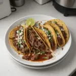 Plate of authentic Birria Tacos garnished with cilantro and onions