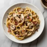 Delicious Bacon Mushroom Pasta served in a bowl with fresh herbs
