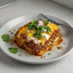A delicious serving of cheesy birria lasagna ready for dipping.