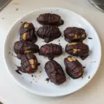 Delicious chocolate-covered peanut butter stuffed dates on a plate