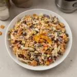 A colorful Cowboy Salad with beans, corn, tomatoes, and avocado in a bowl.